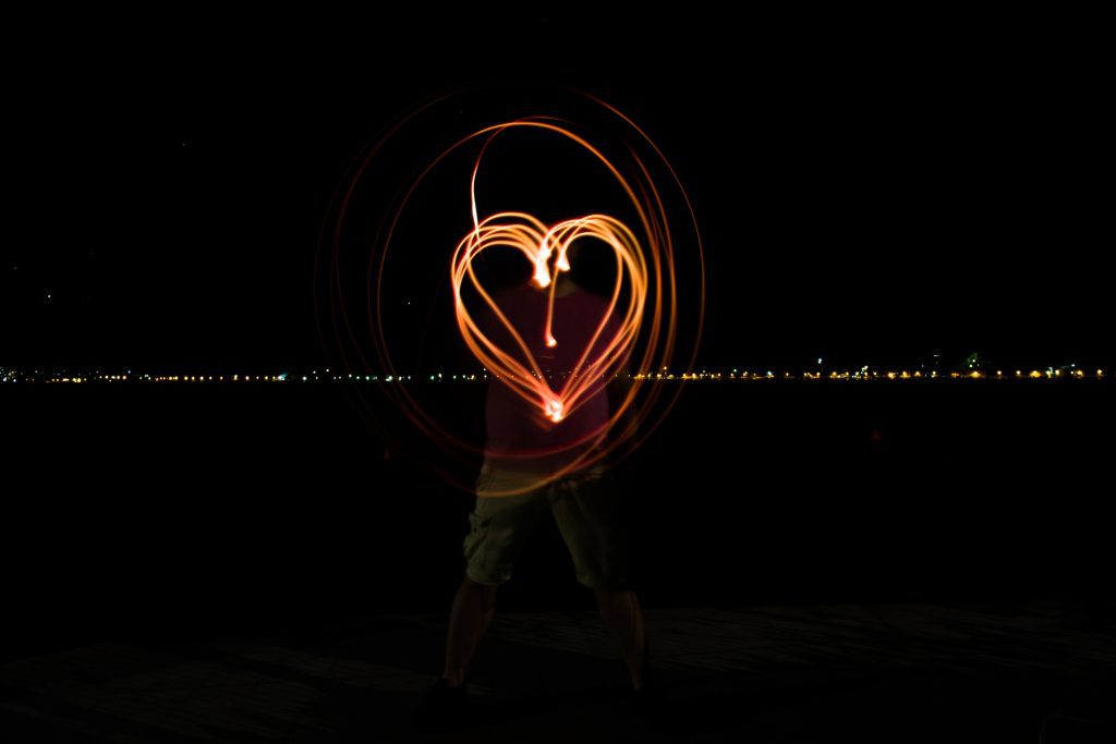 A photo of a man painting heart with light flash
